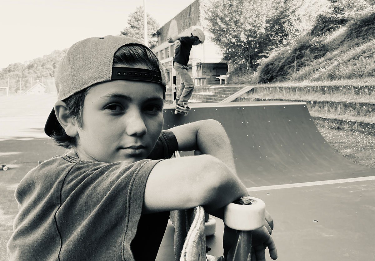 Schüler Lombi vor Sundayramp Minirampe Schüler steht vor einer Minirampe Skateboardrampe auf dem Schulhausplatz Buchberg